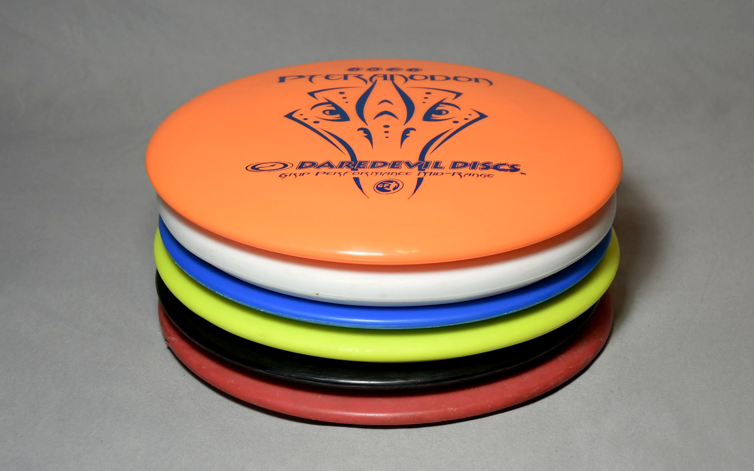 Orange, white, blue, yellow, black and red disc golf discs